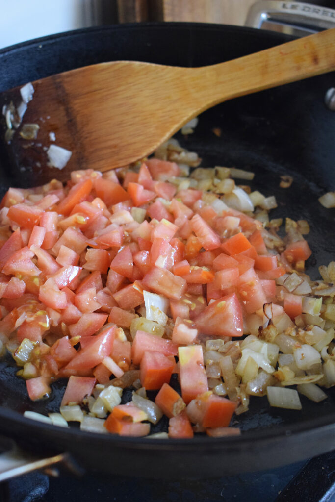 Diced tomatoes and onions in a skillet.