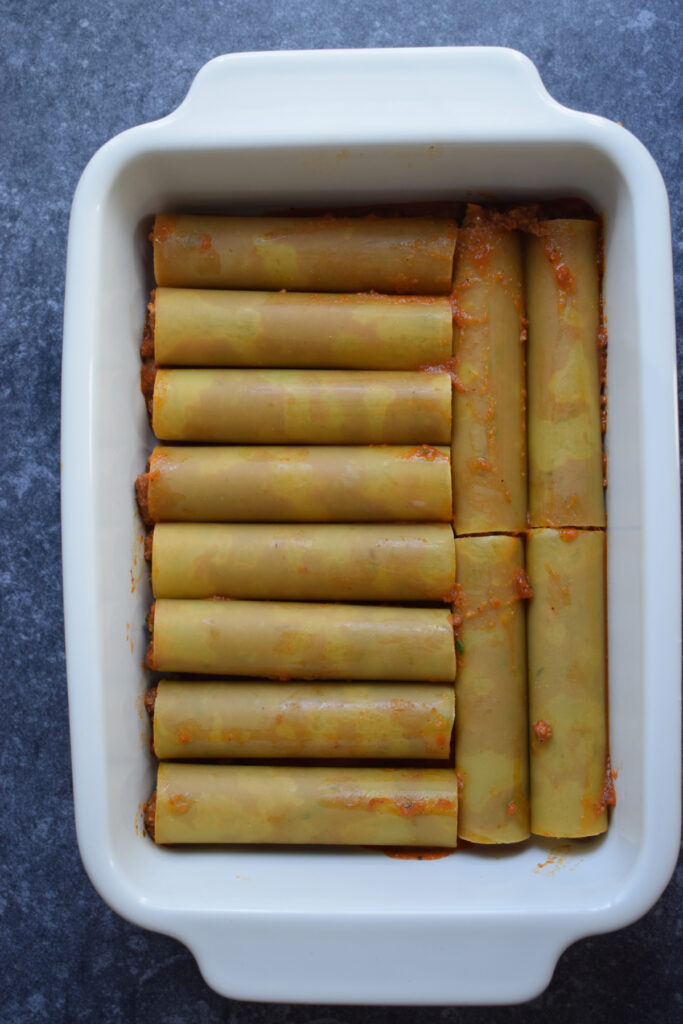 Cannelloni tubes in a baking dish.