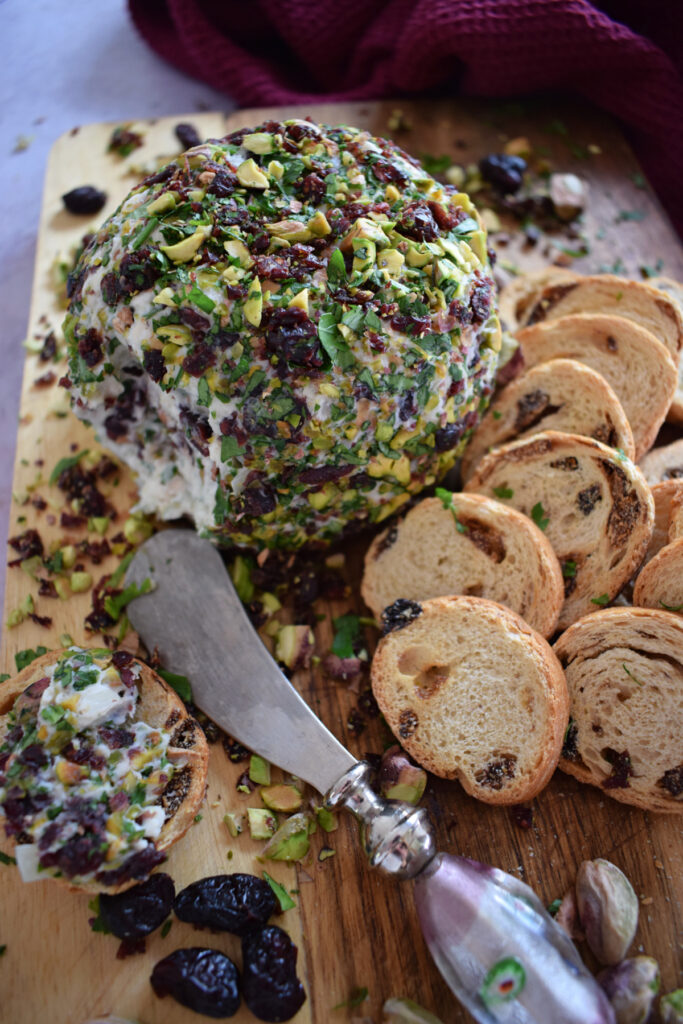 Goat cheese ball with crackers and a serving knife.