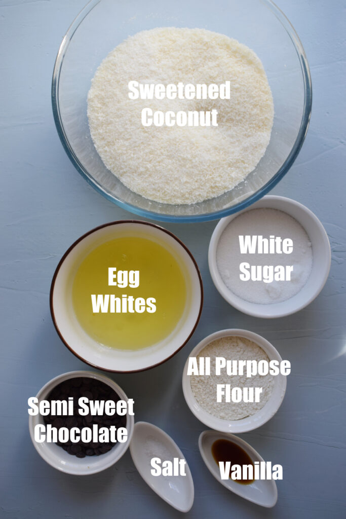 Ingredients to make coconut macaroons on a blue background.