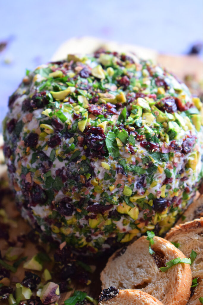 Close up view of a pistachio and cranberry cheese ball.
