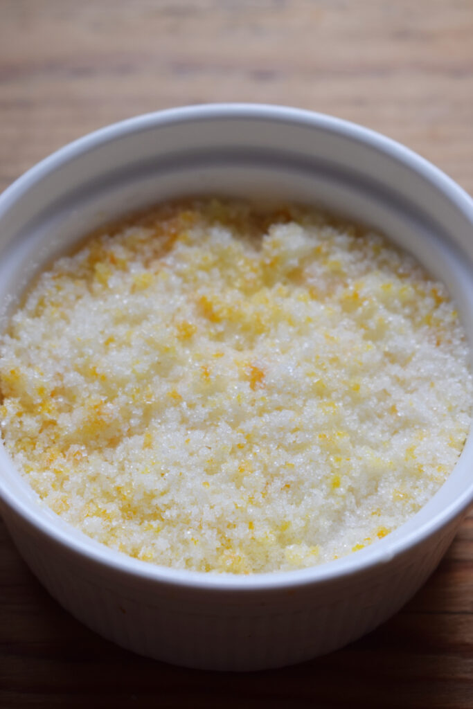 Sugar and orange zest in a small bowl.