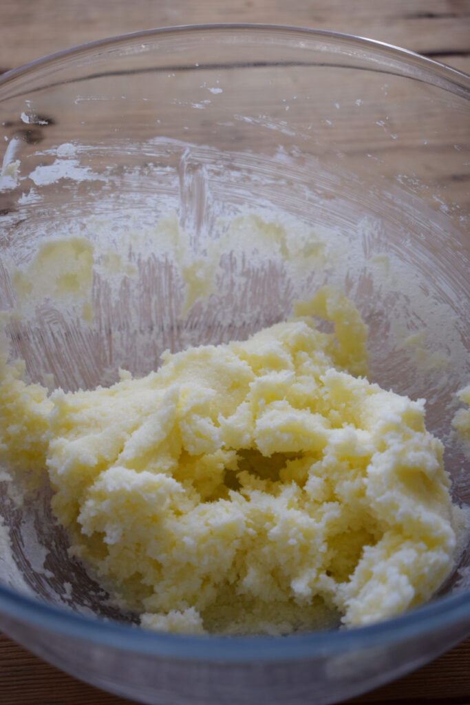 Whipped butter and sugar in a glass bowl.