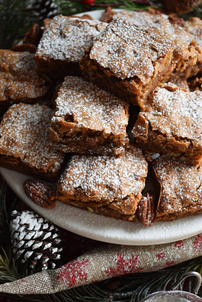 A stack of pecan cookie bars on a plate.
