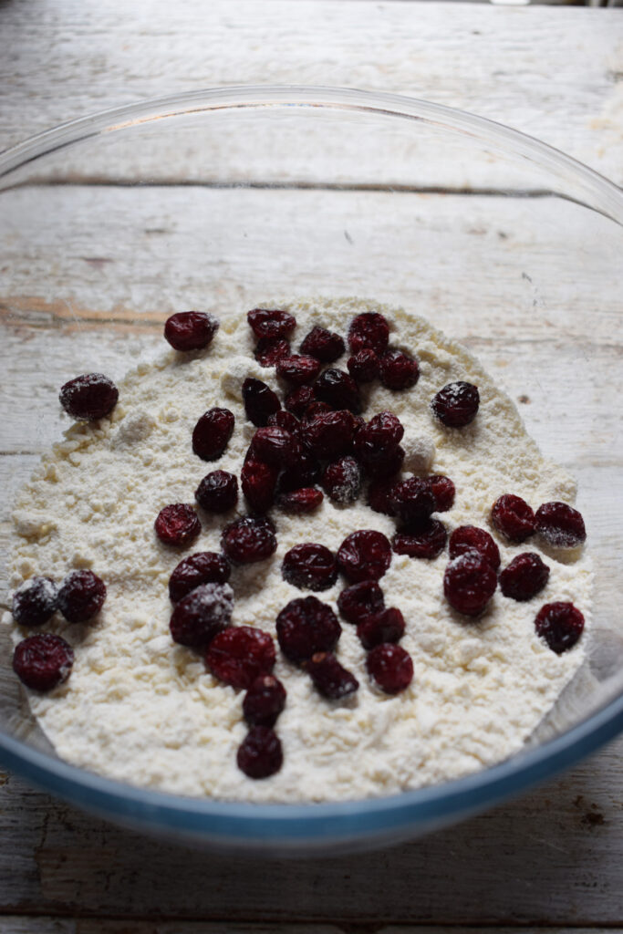 Dry cranberries in a bowl with flour.
