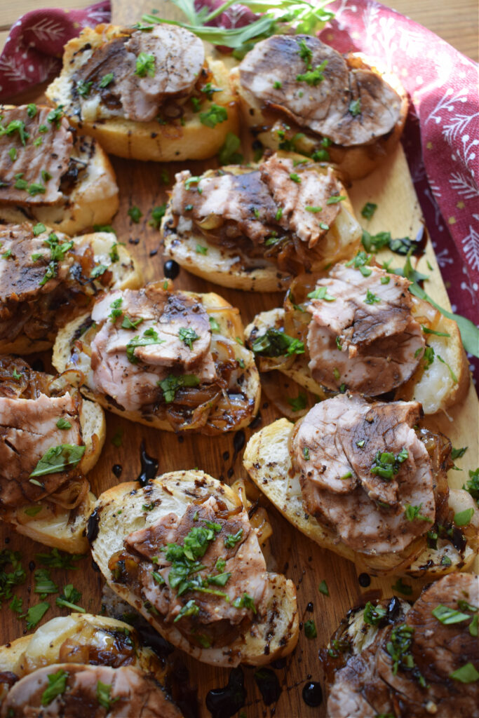 A tray of pork and caramelized onions on baguette bread.