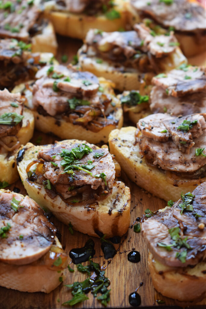 Pork, onions and cheese topped crostini.