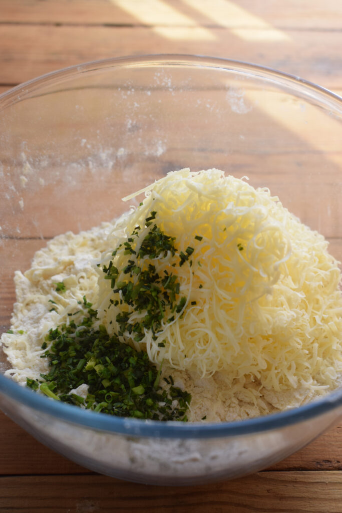 Cheddar and chives in a glass bowl.