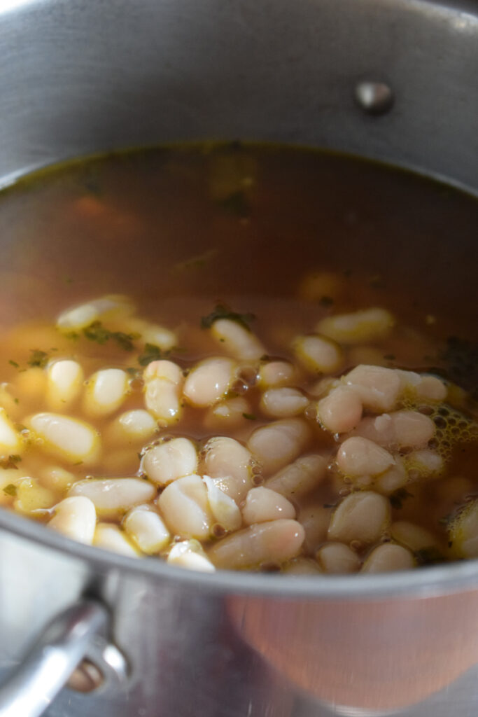 Adding white beans to soup.