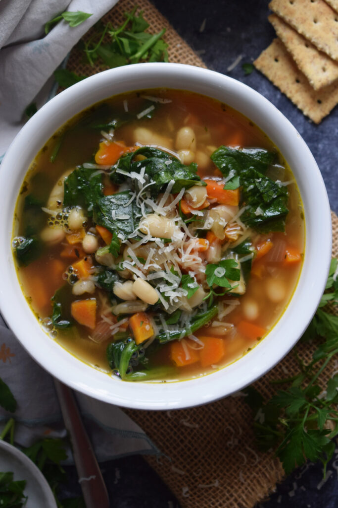 A bowl of soup with crackers on the side.