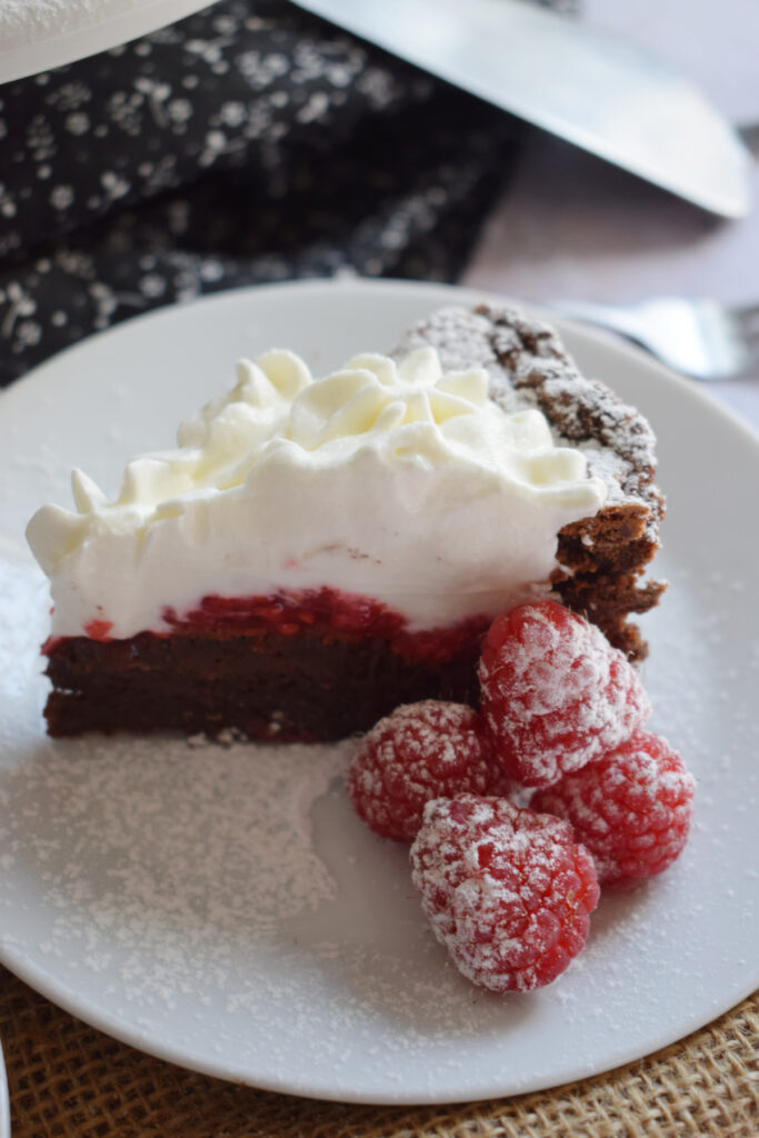 A slice of raspberry chocolate cake on a plate.