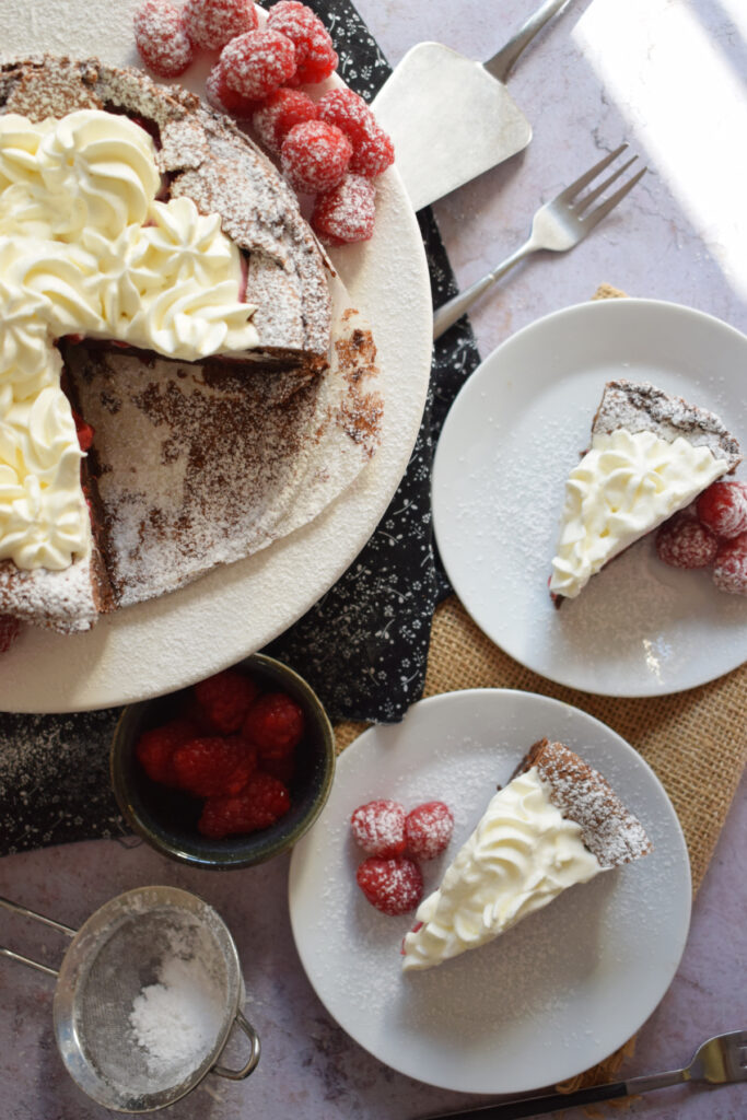 Slices of chocolate and raspberry cake on plates.
