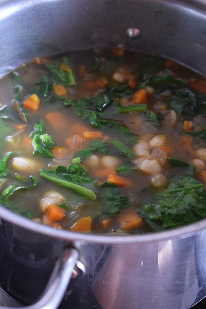 A pot of white bean and spinach soup.