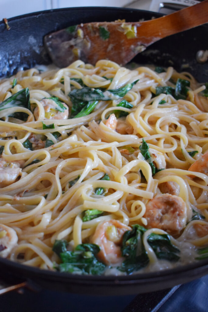 Creamy spinach and shrimp in a skillet.