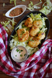 Crispy cod nuggets on a plate with a dip.