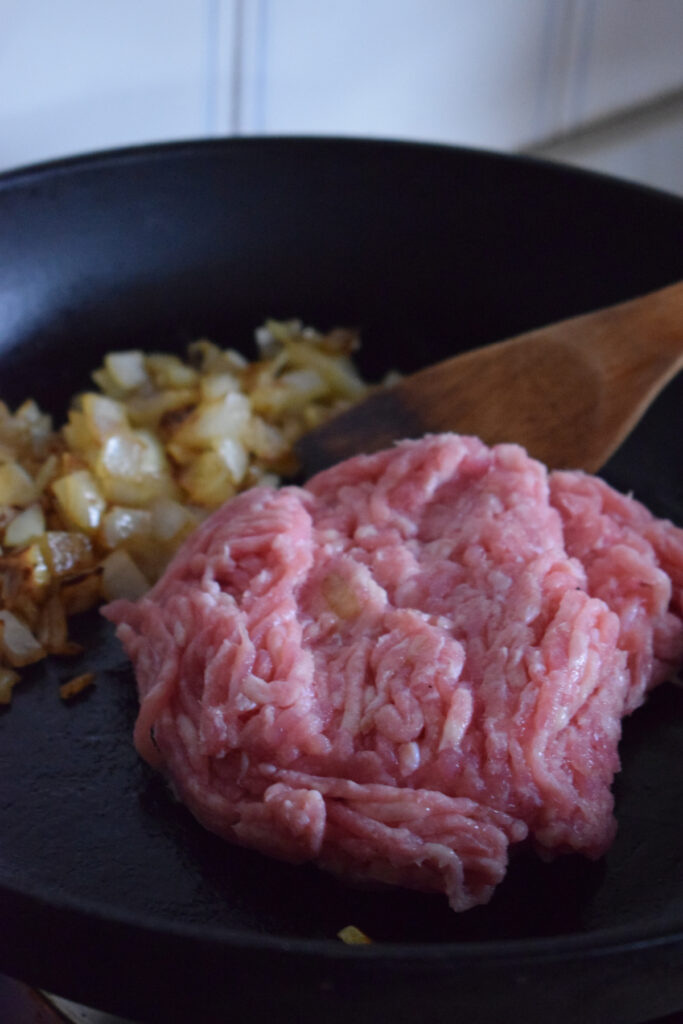 Ground turkey and onions in a skillet.