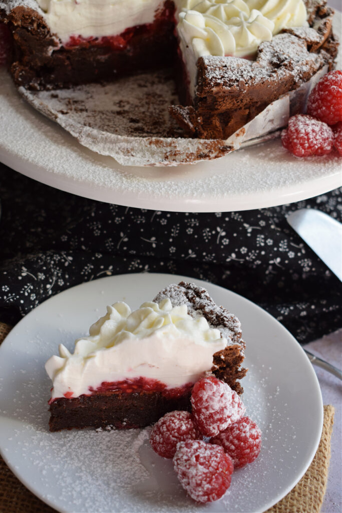 A slice of chocolate and raspberry cake on a plate.