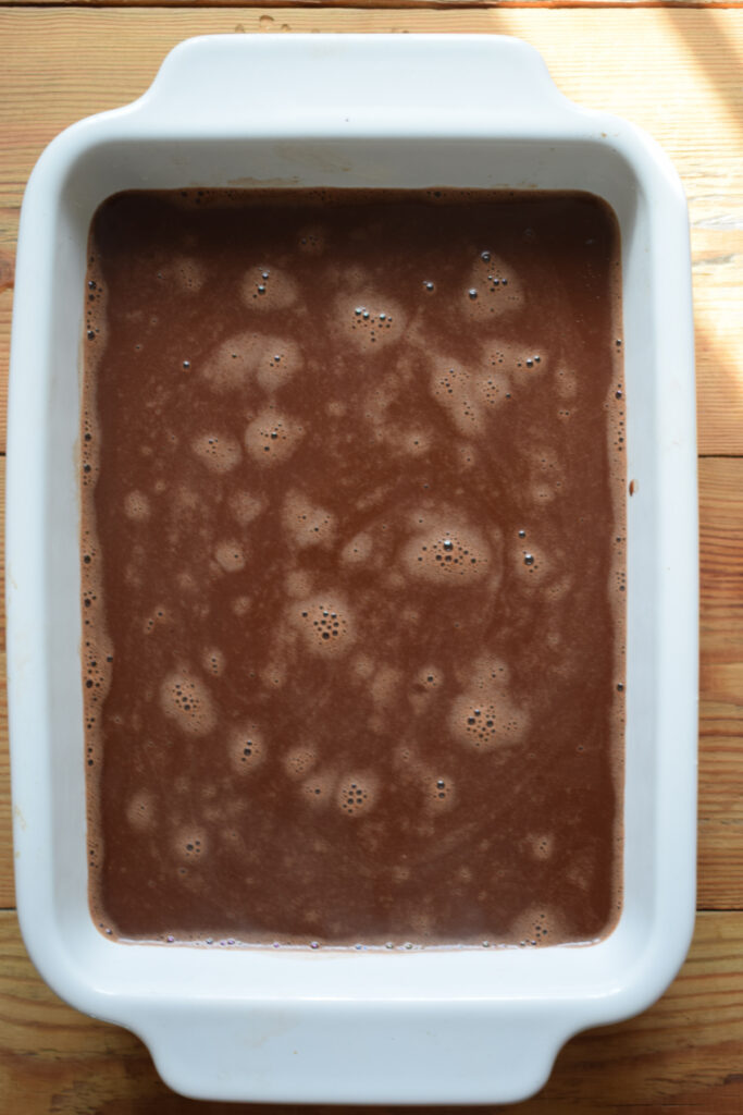 Making a chocolate pudding in a baking dish.