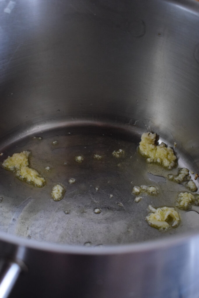 Cooking garlic and olive oil in a pot.