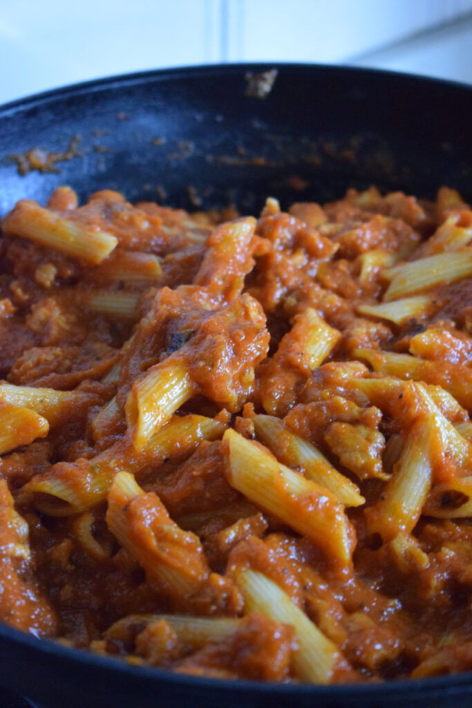 Penne pasta with sauce in a skillet.