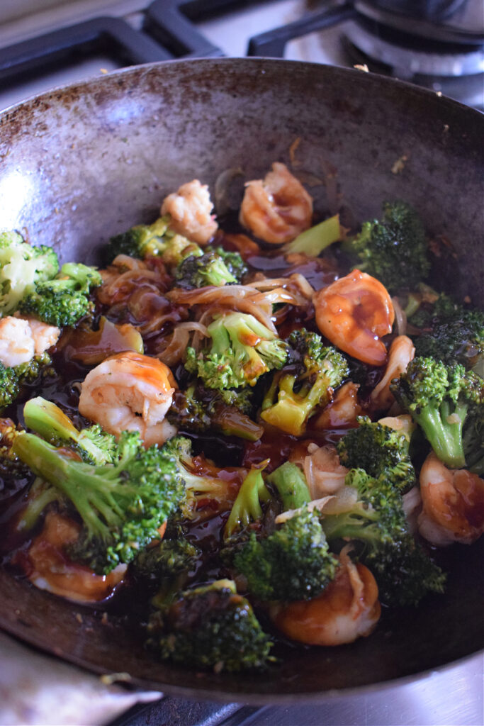 Shrimp and broccoli stir fry in a wok.