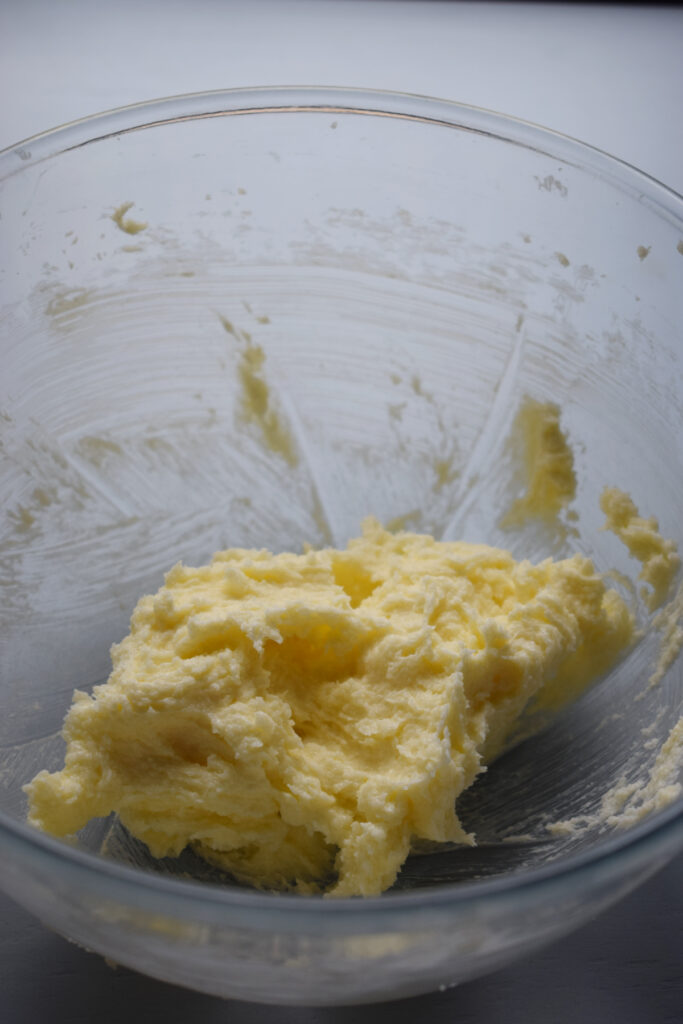 Mixed butter and sugar in a glass bowl.