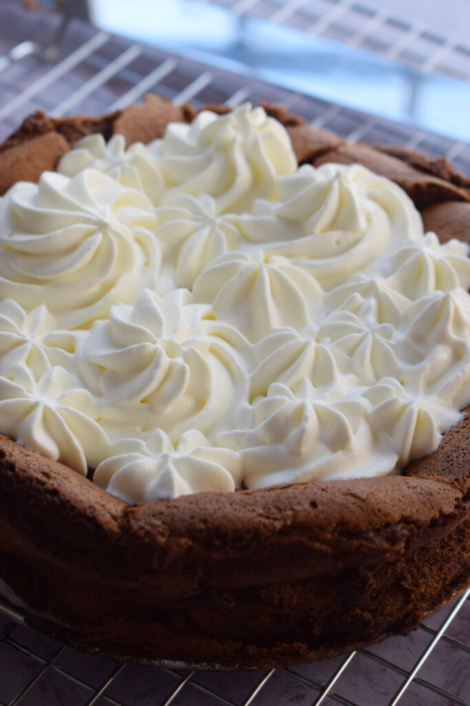 Whipped cream topped chocolate torte.