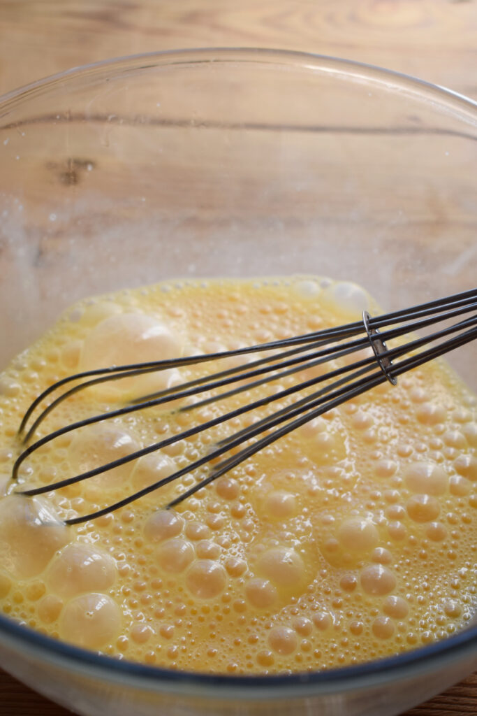 Whisked eggs in a glass bowl.
