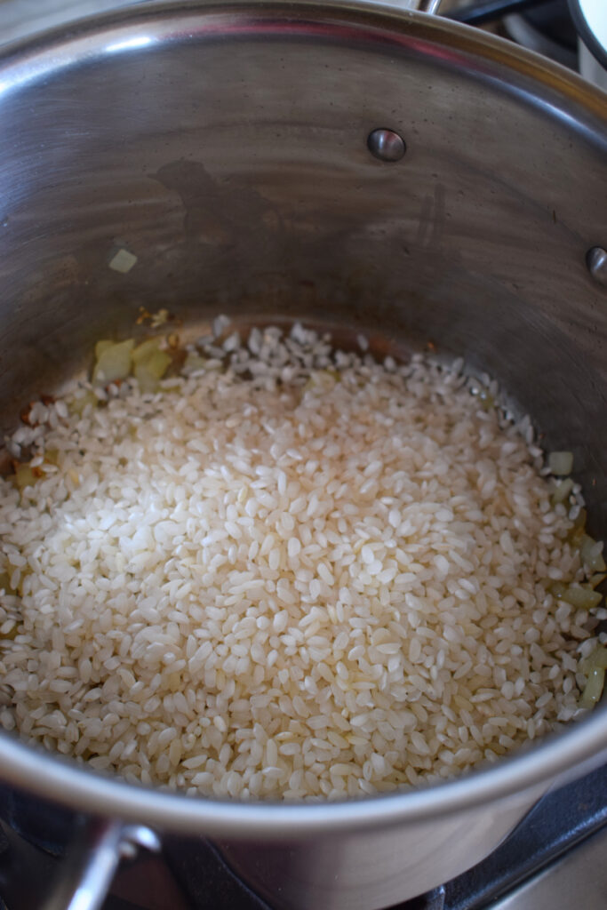 Adding rice to a saucepan.