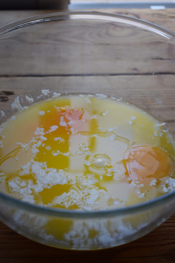 Eggs, sugar and melted butter in a mixing bowl.