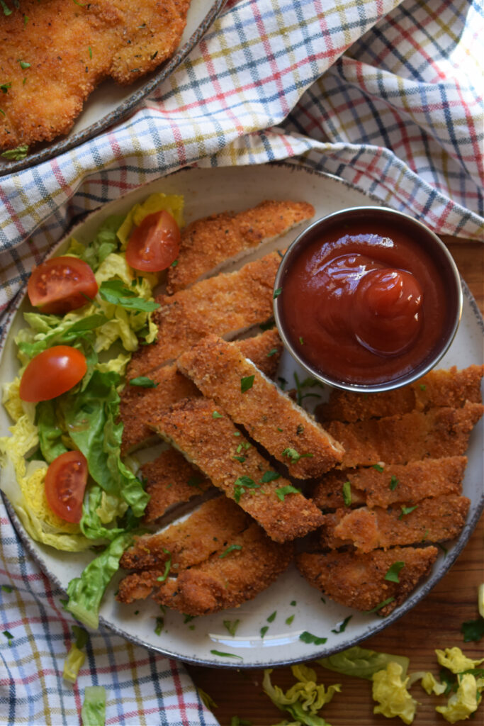 Chicken cut into strips with dipping sauce.