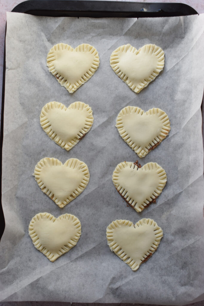 Pastry hearts on a baking tray.