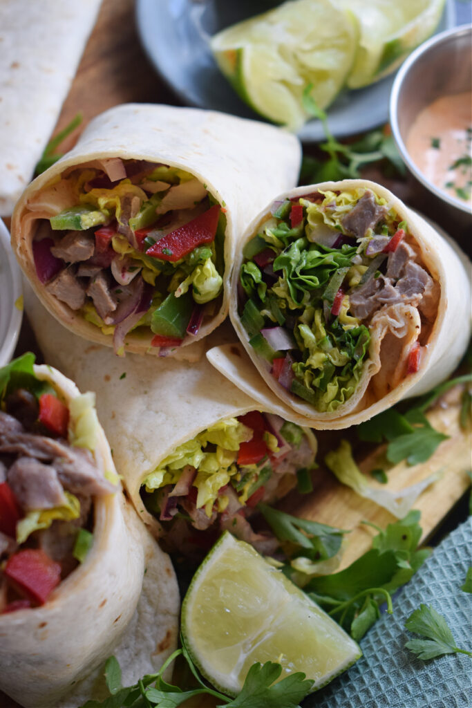 Salad wraps with lime wedges.