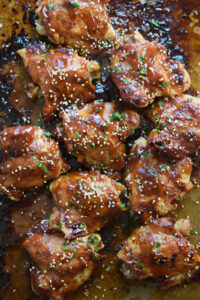 Oven baked teriyaki chicken thighs on a baking tray.