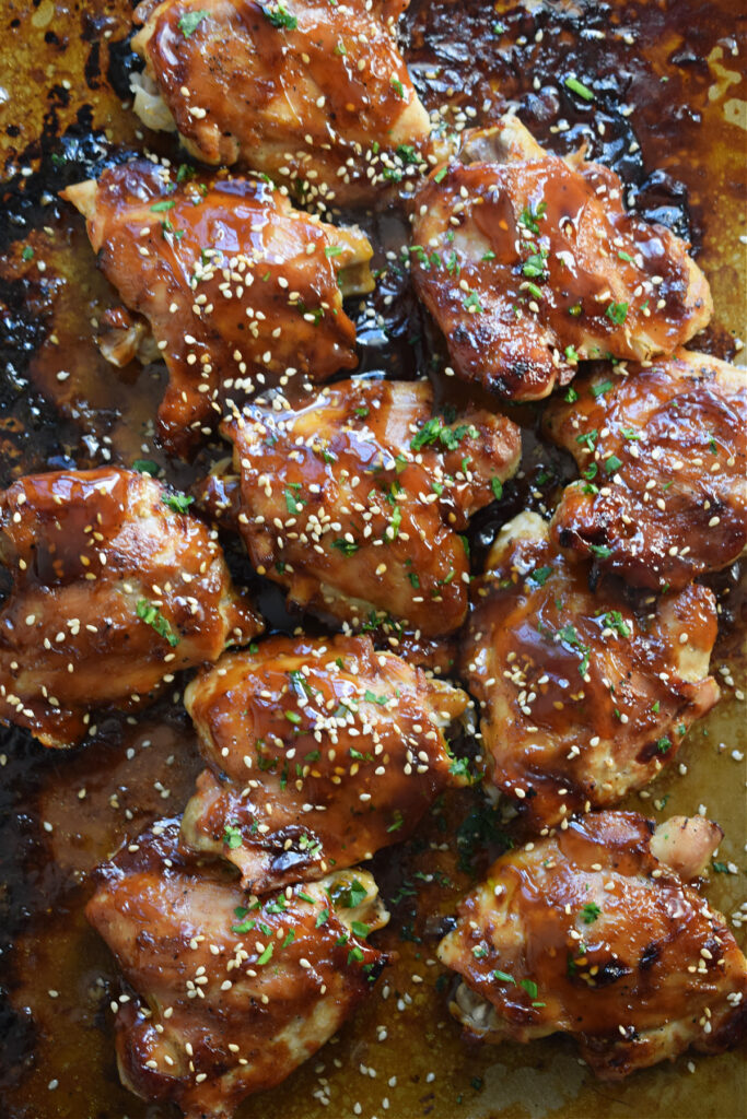 Oven baked teriyaki chicken thighs on a baking tray.