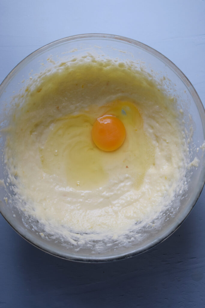 Adding an egg to cookie batter.