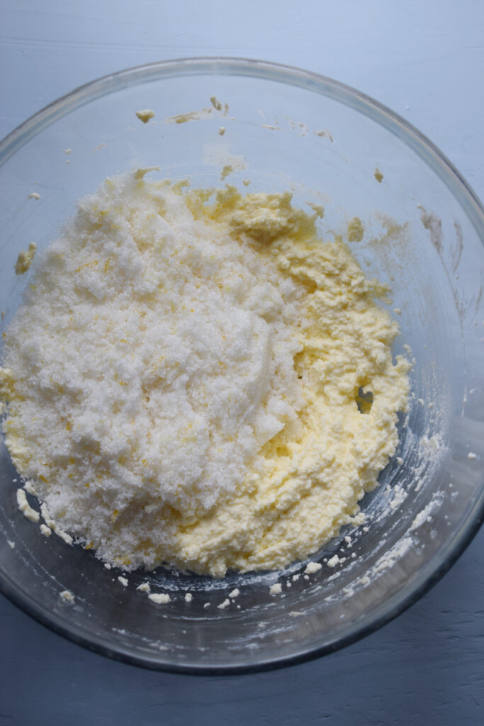 Sugar in a bowl with whipped butter.
