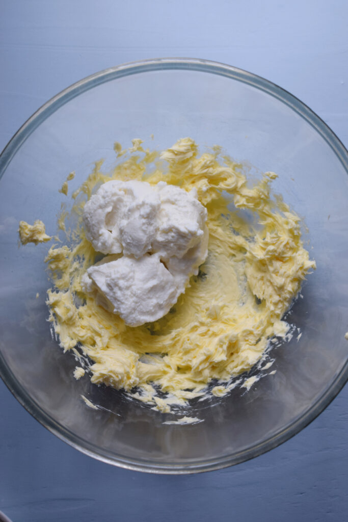 Ricotta cheese and butter in a mixing bowl.