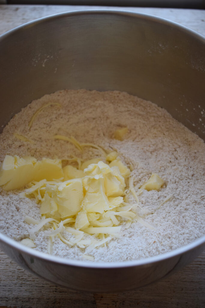 Adding butter to flour.