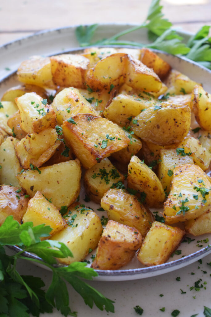 Spiced potatoes on a plate with herbs.