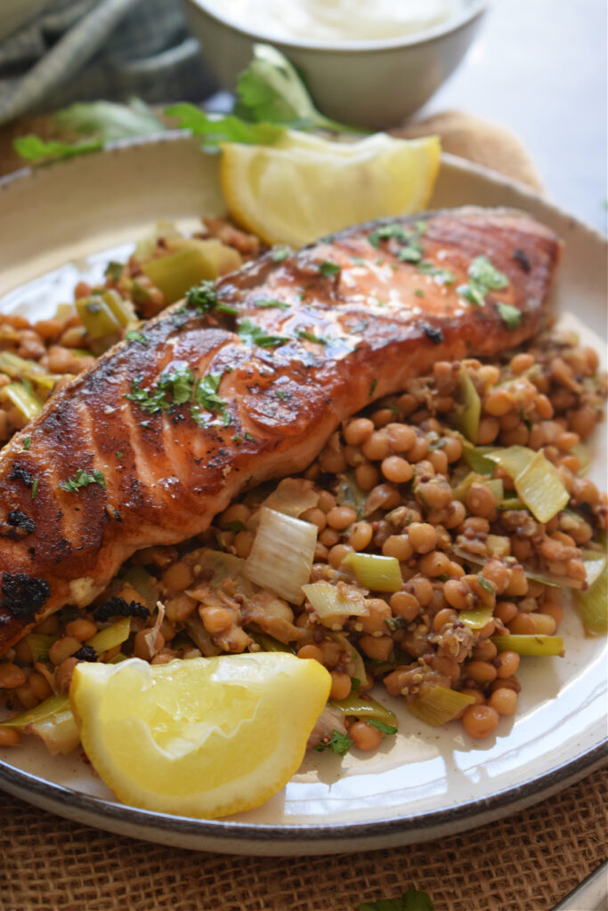 Cooked salmon served over a bed of lentils.