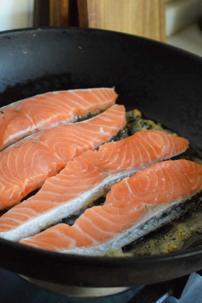 Cooking salmon in a skillet.