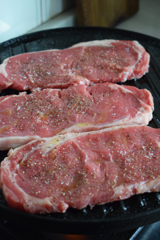 Cooking steak on a cast iron pan.