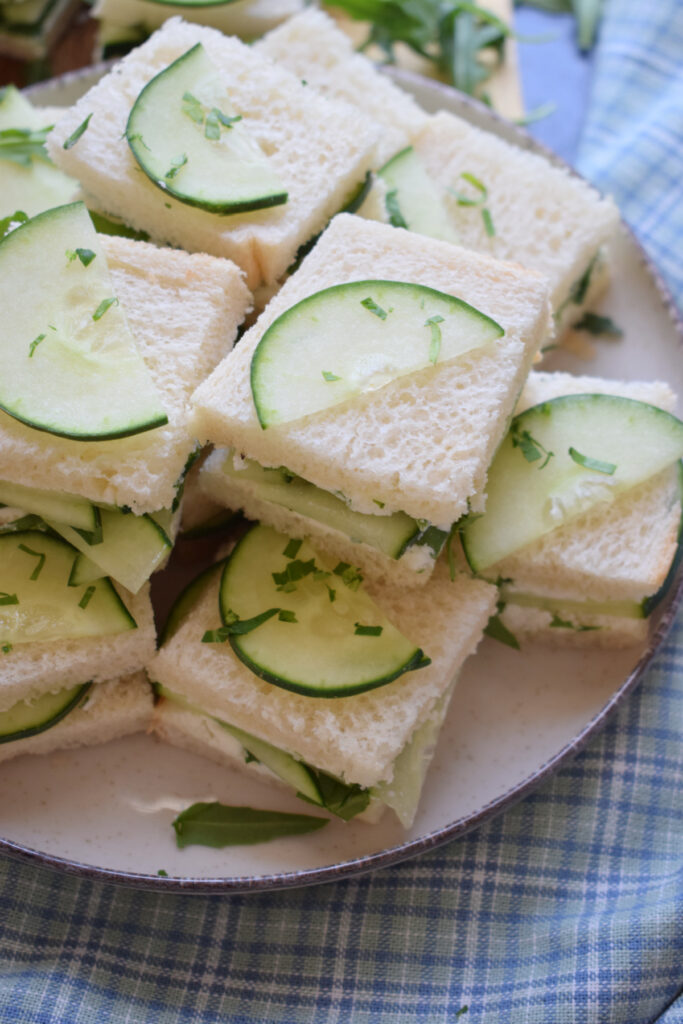 Mini cucumber tea sandwiches on a plate.