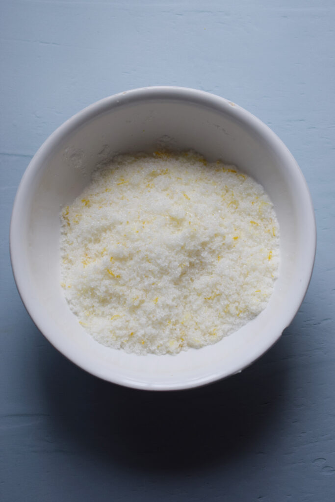 Sugar and lemon zest mixed in a bowl.