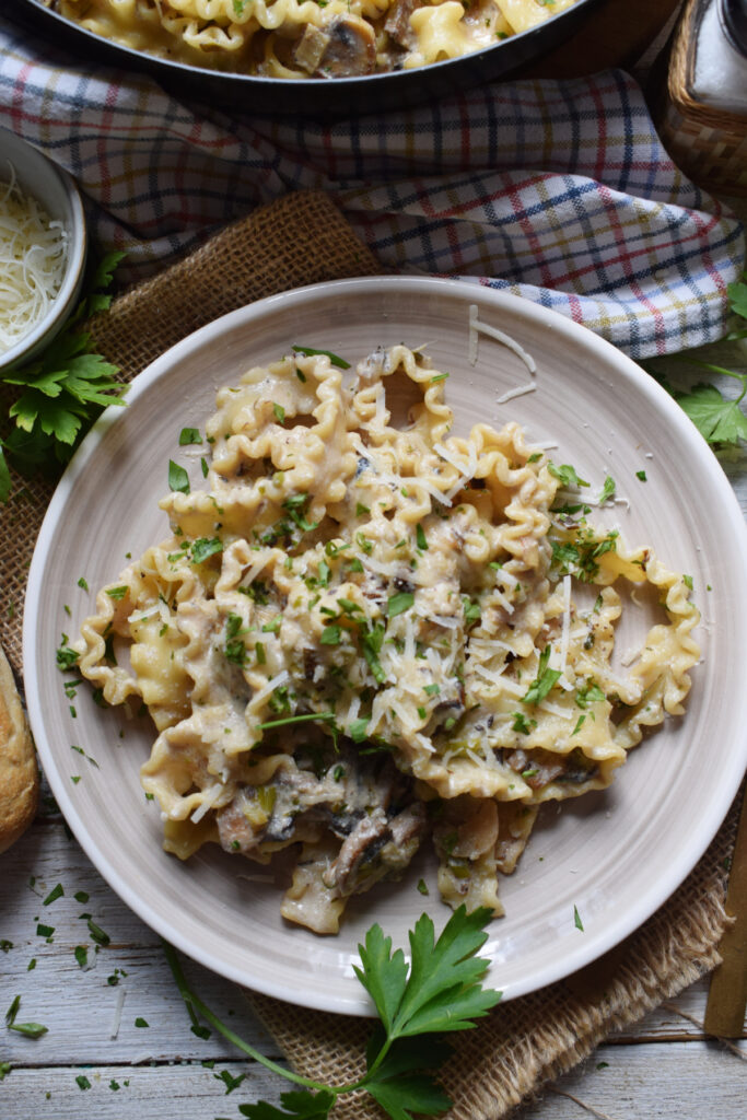 Mushroom pasta on a plate with herbs.