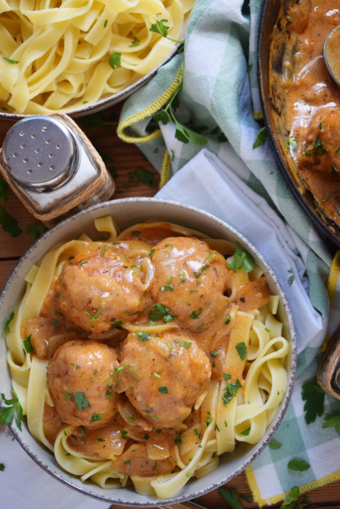 Overhead view of turkey meatballs in a bowl with noodles.