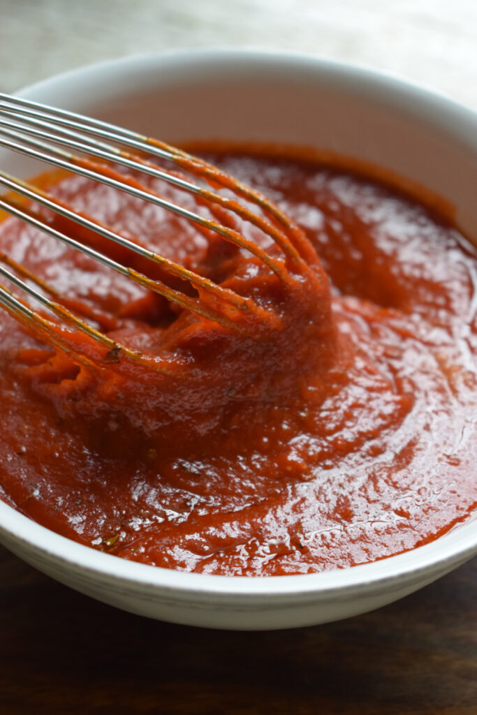 Whisked pizza sauce in a bowl.