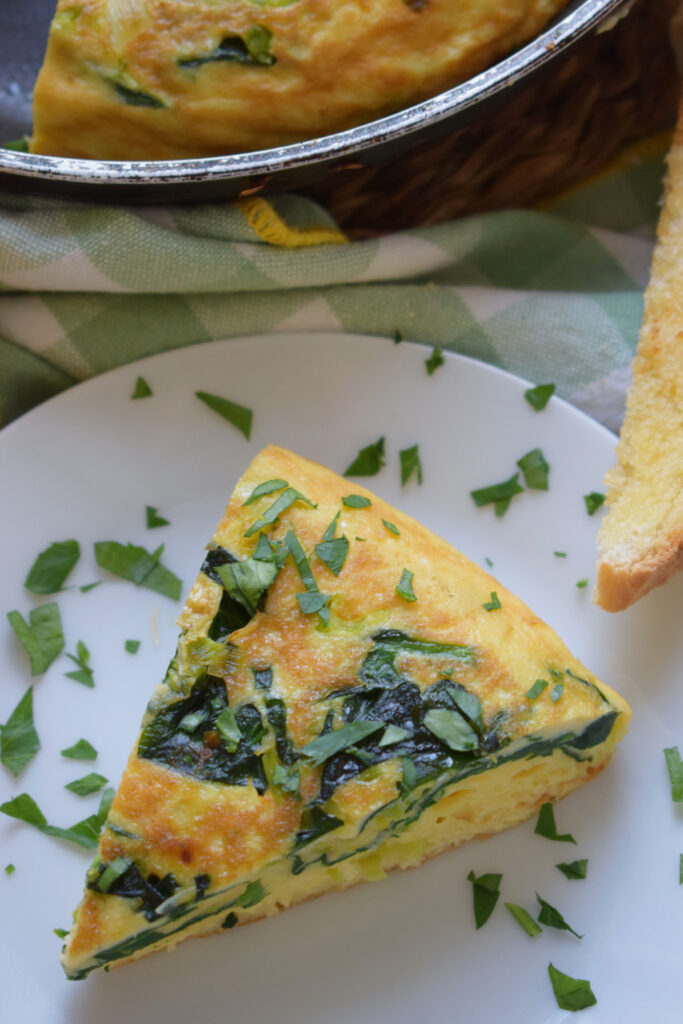 A slice of frittata on a plate.