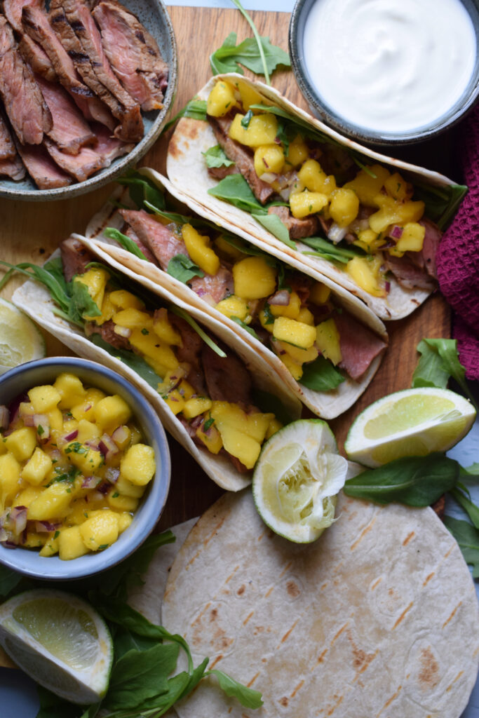 Steak tacos with mango salsa and sour cream.